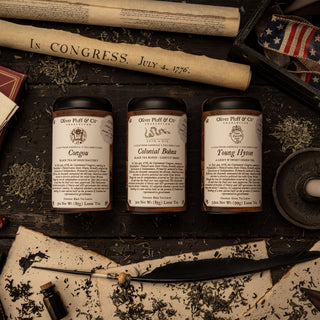 three commemorative tins face up on tabletop surrounded by american colonial memorabilia