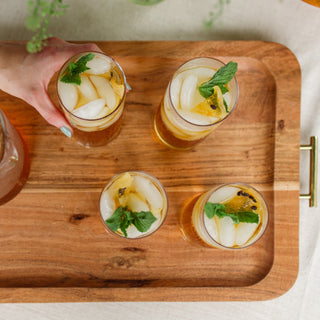 four glasses of brewed iced tea on wooden tray