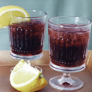 two glasses of ice tea with lemon slices on a bronze platter